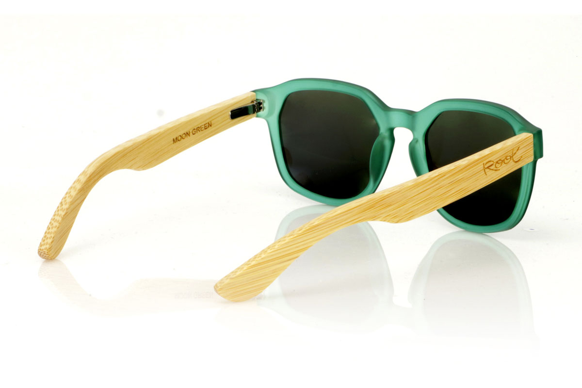 Wood eyewear of Maple MOON GREEN. MOON GREEN sunglasses are the freshness you are looking for to complete your look. With a hexagonal frame in an eye-catching matte transparent green, these glasses are the definition of unique style. The temples, made of maple wood, add that natural and subtle touch, making each pair something special. The combination is not only visually attractive, but also comfortable and practical for everyday use. Whether for a walk through the city or a getaway to nature, the MOON GREEN accompanies you with style and protection. Front measurement: 148x50mm. Caliber: 53. for Wholesale & Retail | Root Sunglasses® 